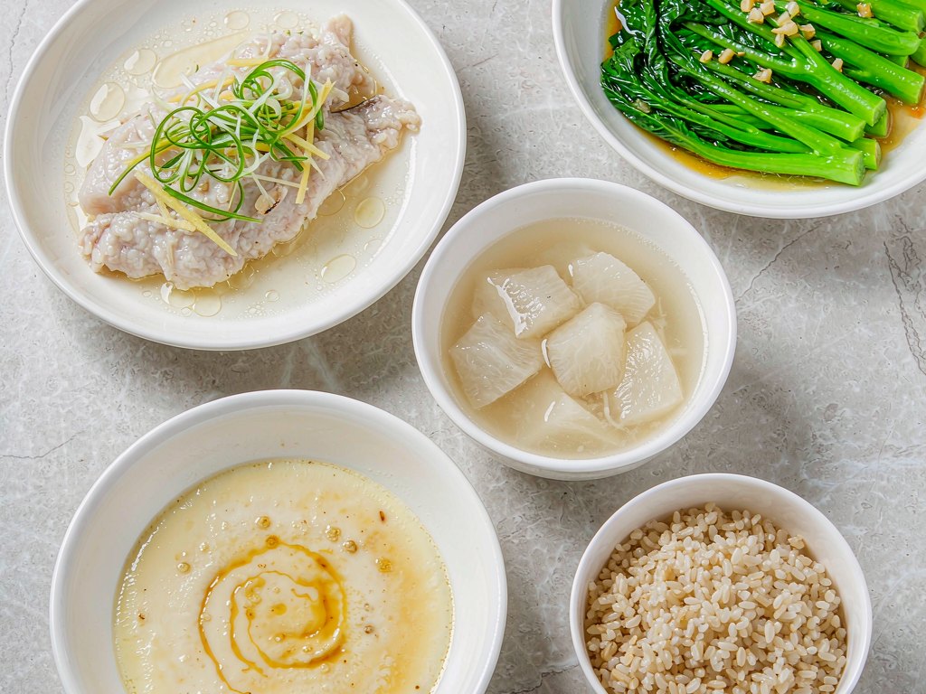 清蒸鱼片、白灼芥蓝、蒸蛋羹和一碗杂粮饭摆在石桌上