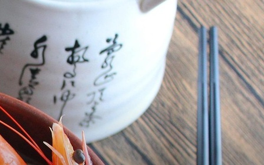 饭后桌面收拾干净：白瓷茶壶、筷子和木桌（实拍）